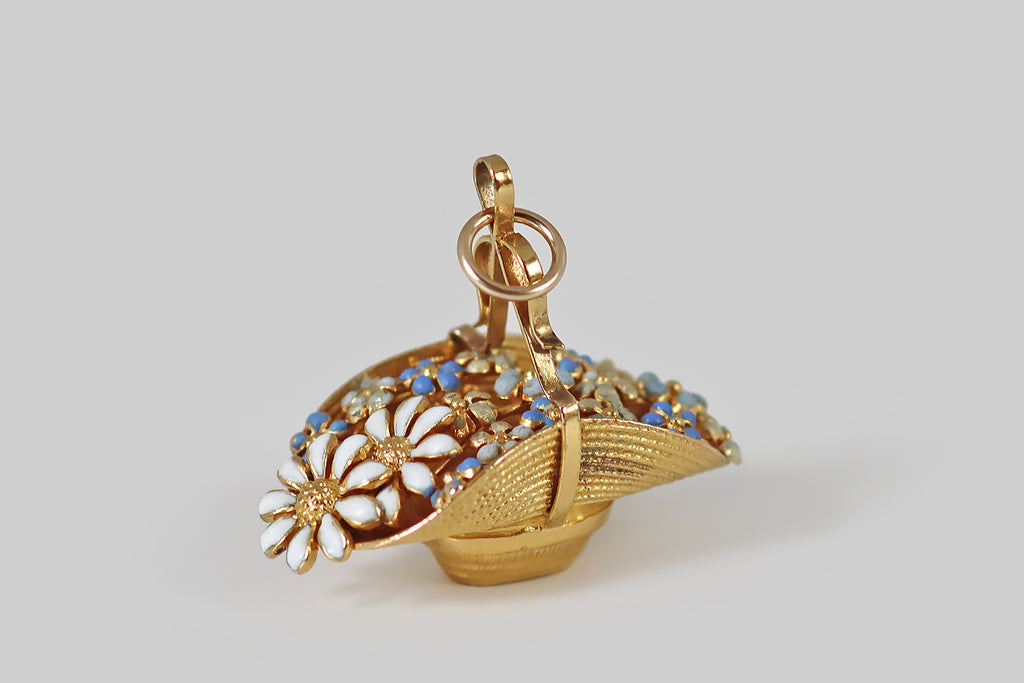 Poor Mouchette | Curated Antique Jewelry, Vintage Jewelry & Engagement Rings | Portland, Oregon | A darling turn of the century charm, modeled in 14k yellow gold as a straw hat, filled to overflowing with daisies and forget me nots! These enameled flowers are clustered naturalistically across the hat's opening, which is pinched closed by a curling ribbon handle. This miniature is especially realistic