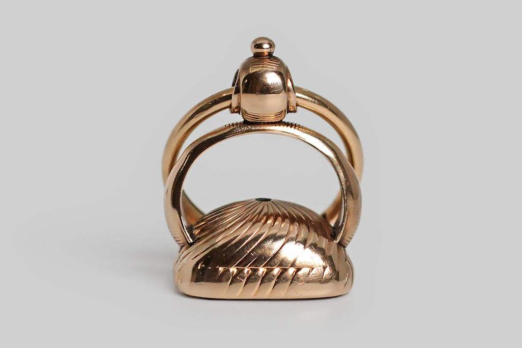 A wonderful, early-Victorian wax seal fob, modeled in 15k rose gold, whose bezel-set, agate (carnelian) seal features an intaglio carved rebus. This rebus puzzles out to mean: I hope you are well! An anchor was the popular symbol for hope during the Victorian era, and the tree in this diagram is a Yew tree. The fob itself is classically formed, with a broad stirrup-shaped arch, a round finial bail, and fine, hand-engraved lines, both straight and pinwheeling.