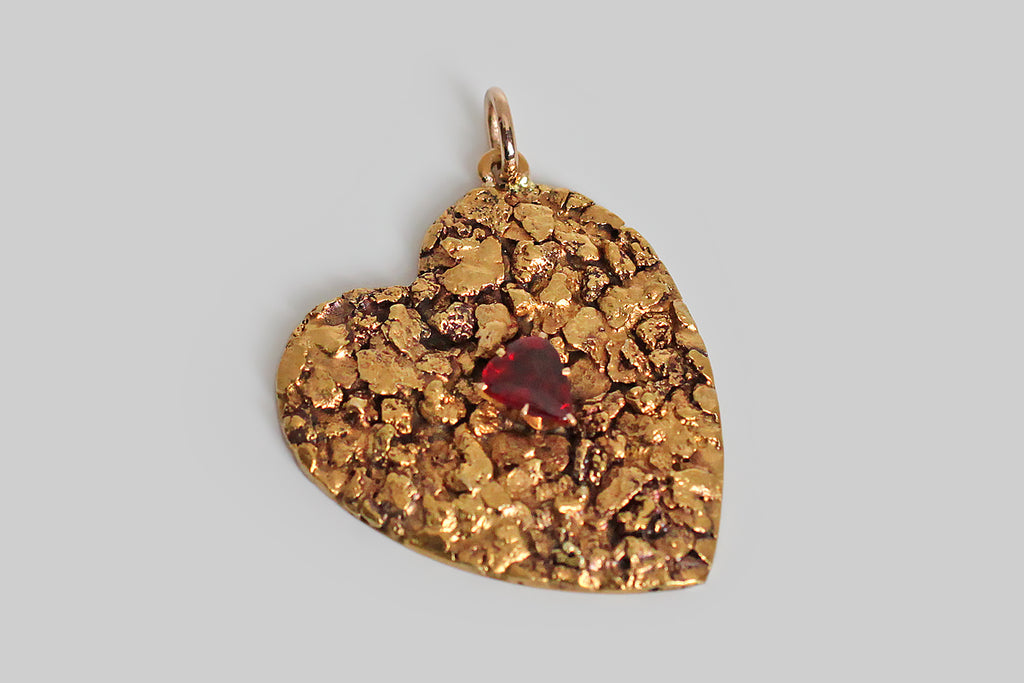 Poor Mouchette | Curated Antique Jewelry, Vintage Jewelry & Engagement Rings | Portland, Oregon | An extra large, Victorian-era heart pendant, covered edge-to-edge in natural gold nuggets. These gold nuggets have a rich, high, gold color, and fascinating organic textures. A sanguine, heart-shaped, garnet doublet rests amid these nuggets, in six, claw-like prongs. The heart's backplate is pierced from 14k gold sheet