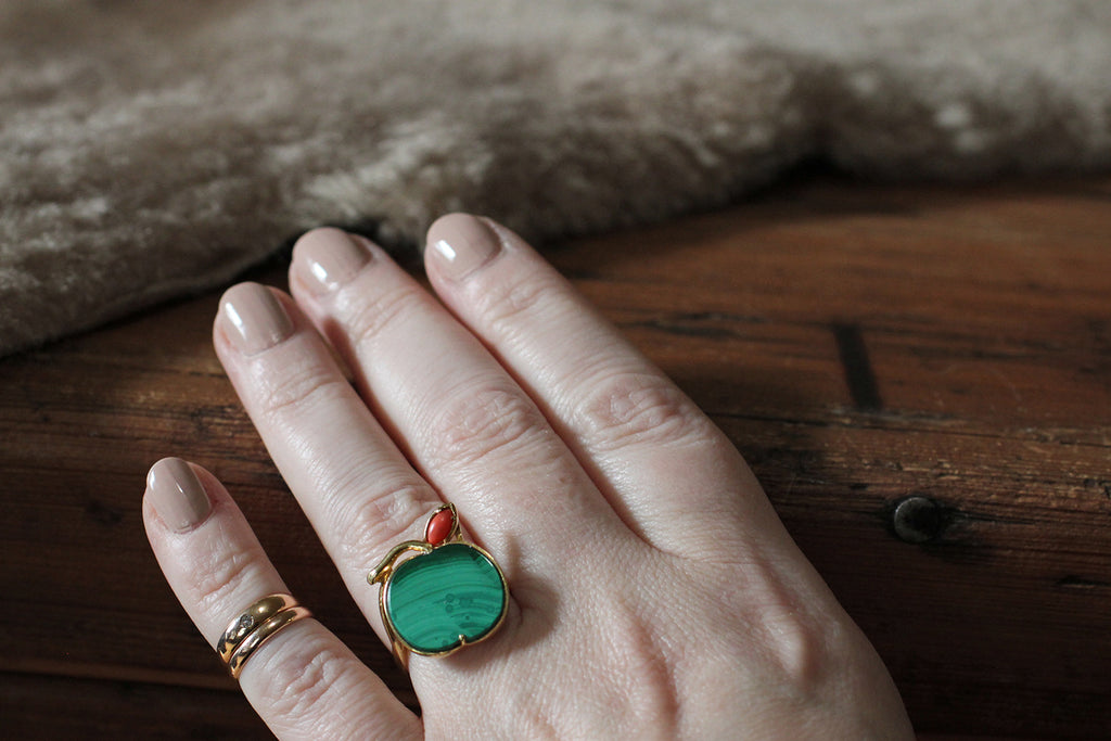 Poor Mouchette | Curated Antique Jewelry, Vintage Jewelry & Engagement Rings | Portland, Oregon | A playful, mid 20th century ring, modeled in 18k yellow gold, whose face takes the form of an apple. The body of this apple is a beautifully-figured, flush-set, polished, malachite slab. A small coral leaf perches atop the green fruit, alongside its curved, gold stem. This ring's low-profile setting is highly-structured and airy, with a bypass-style shank