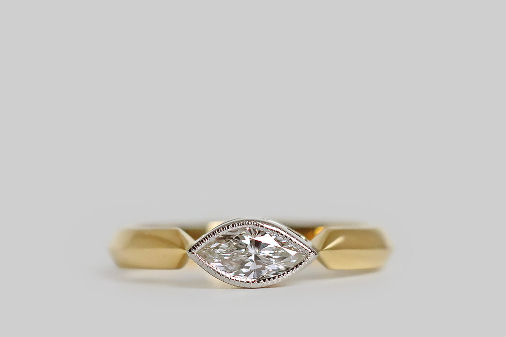 Poor Mouchette | Curated Antique Jewelry, Vintage Jewelry & Engagement Rings | Portland, Oregon | An elegant, low-profile engagement ring, modeled in 18k yellow gold and platinum, whose gem is an east/west oriented, vintage, marquise-cut diamond (.61 carats, G/H, VS). Our sparkling, eye-like diamond is set in a platinum bezel. This bezel is finished with a fine, milgrained edge, and it rests between the the shapely end-points of the ring's crisp cathedral shoulders.