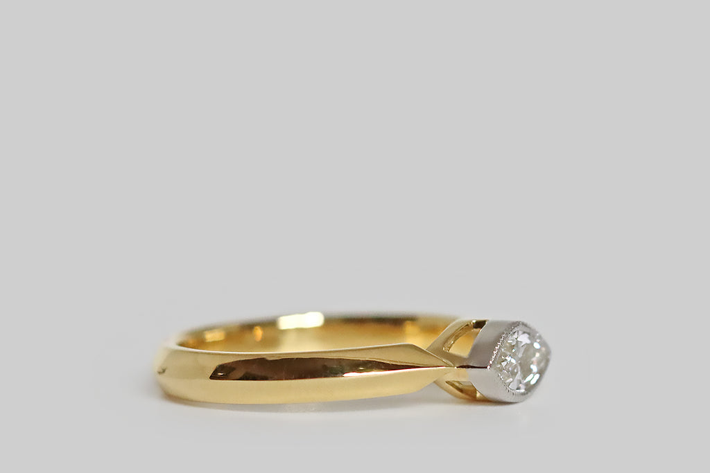 Poor Mouchette | Curated Antique Jewelry, Vintage Jewelry & Engagement Rings | Portland, Oregon | An elegant, low-profile engagement ring, modeled in 18k yellow gold and platinum, whose gem is an east/west oriented, vintage, marquise-cut diamond (.61 carats, G/H, VS). Our sparkling, eye-like diamond is set in a platinum bezel. This bezel is finished with a fine, milgrained edge, and it rests between the the shapely end-points of the ring's crisp cathedral shoulders.