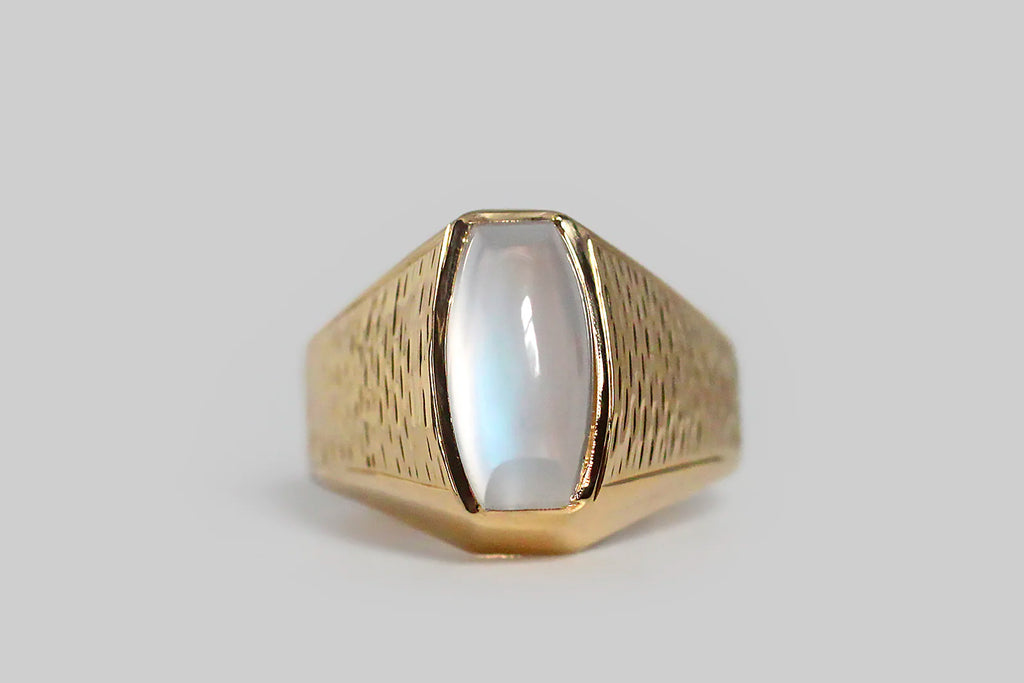 Poor Mouchette | Curated Antique Jewelry, Vintage Jewelry & Engagement Rings | Portland, Oregon | A striking vintage ring, modeled in 18k yellow gold, and set with a blue-flash moonstone of rare quality. This ring's modified sugarloaf moonstone is bezel set, and it really sings— the surface of its backside is completely covered by the iridescent play of blue and pink color that makes the best moonstones so breathtaking.