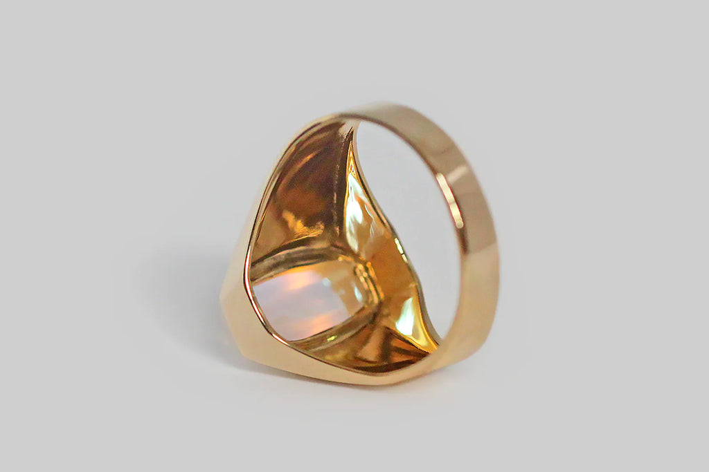 Poor Mouchette | Curated Antique Jewelry, Vintage Jewelry & Engagement Rings | Portland, Oregon | A striking vintage ring, modeled in 18k yellow gold, and set with a blue-flash moonstone of rare quality. This ring's modified sugarloaf moonstone is bezel set, and it really sings— the surface of its backside is completely covered by the iridescent play of blue and pink color that makes the best moonstones so breathtaking.