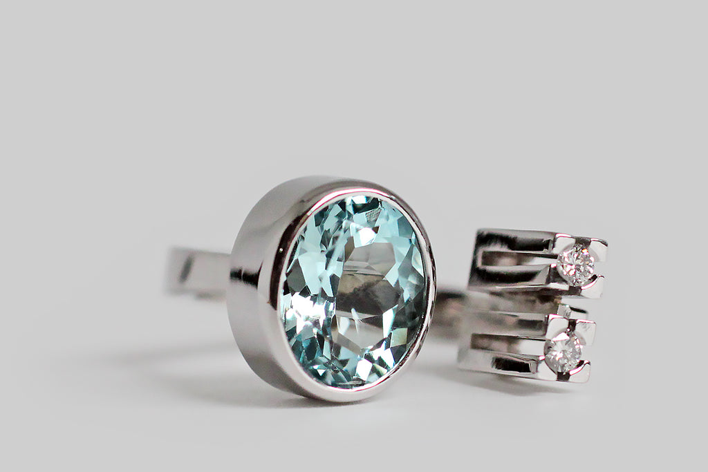 Poor Mouchette | Curated Antique Jewelry, Vintage Jewelry & Engagement Rings | Portland, Oregon | A exceptional vintage cocktail ring, substantially-modeled in 14k white gold, by the beloved Danish designer, Ole Lynggaard. This challenging, modernist darling features an icy, 2.6 carat, faceted aquamarine, and a pair of 2.25 mm brilliant cut white diamonds. The oval aquamarine gem is held in a deep, smooth bezel