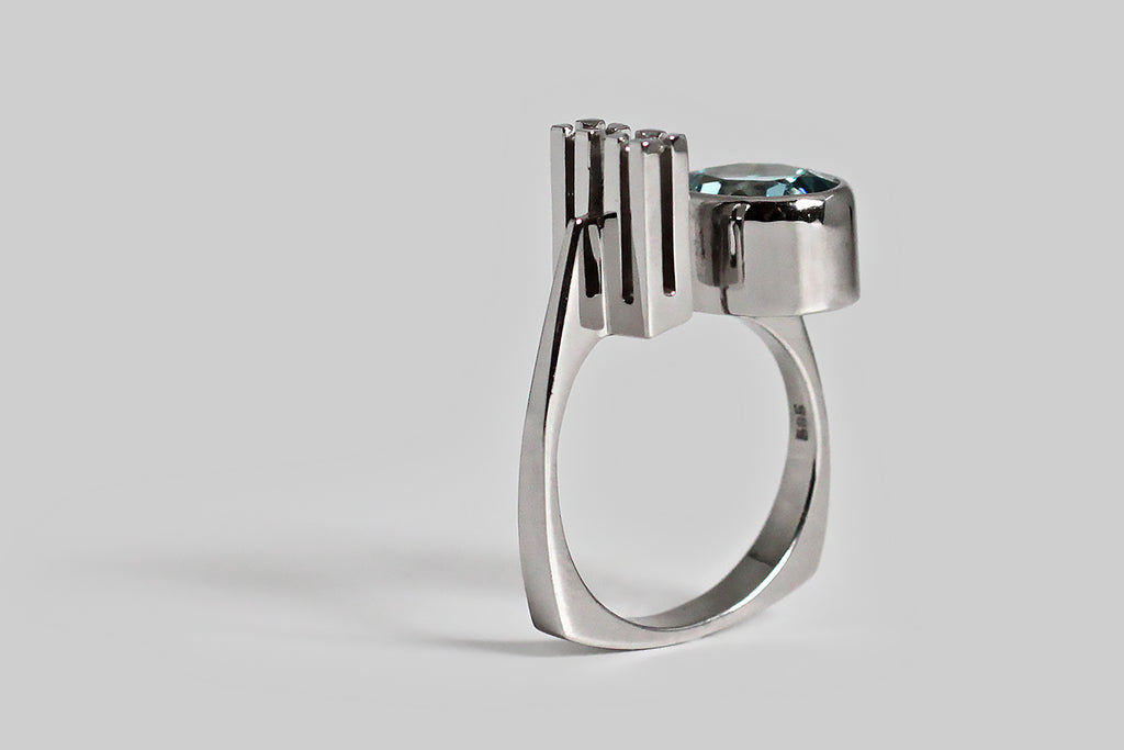 Poor Mouchette | Curated Antique Jewelry, Vintage Jewelry & Engagement Rings | Portland, Oregon | A exceptional vintage cocktail ring, substantially-modeled in 14k white gold, by the beloved Danish designer, Ole Lynggaard. This challenging, modernist darling features an icy, 2.6 carat, faceted aquamarine, and a pair of 2.25 mm brilliant cut white diamonds. The oval aquamarine gem is held in a deep, smooth bezel