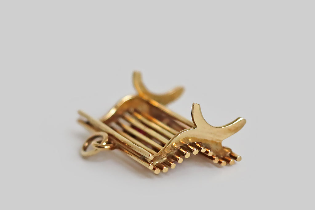 Poor Mouchette | Curated Antique Jewelry, Vintage Jewelry & Engagement Rings | Portland, Oregon | A sweet, sentimental, vintage charm, realistically hand-fabricated in 14k yellow gold, to recall a park bench. This miniature bench is made of a series of round gold wires, that perch atop hand-pierced legs— these "slats" curve to create a cozy, realistic bench seat. A pair of bezel-set, heart-shaped rubies rest on our bench, symbolizing two lovers.