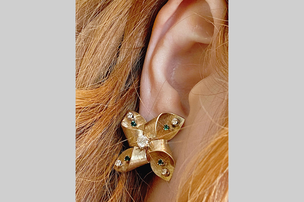 Poor Mouchette | Curated Antique Jewelry, Vintage Jewelry & Engagement Rings | Portland, Oregon | A glamorous pair of mid-twentieth-century ear clips, modeled in 14k yellow gold, and set with a suite of old cut diamonds and emeralds. These ear clips are fabricated in the form of pinwheels, and they have wonderful dimensionality! They are textured, all-over, with a fine, engraved pattern of lines that follow the curves of the earrings and play beautifully with light.