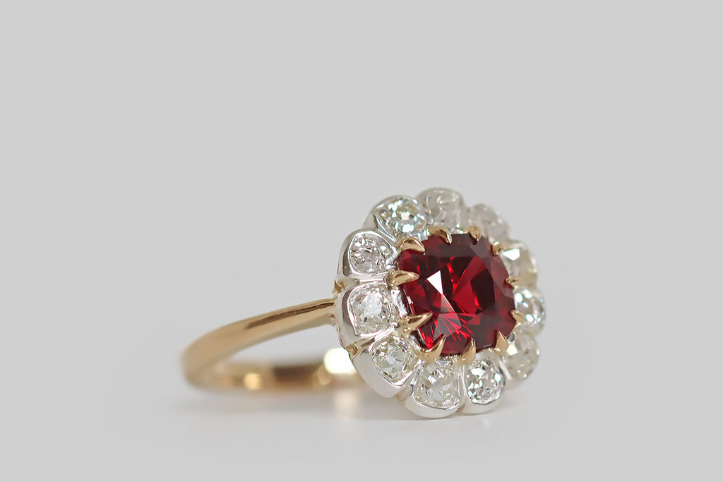 Poor Mouchette | Curated Antique Jewelry, Vintage Jewelry & Engagement Rings | Portland, Oregon | A lovely, antique, flower-form cluster ring, modeled in 18k yellow gold and silver, whose primary gem is a natural, cushion-cut red spinel (unheated, Burma). This vivid, true-red gem is held in a series of eleven tapering, claw-like prongs, where it is surrounded by eleven bezel-set, old mine cut diamonds.