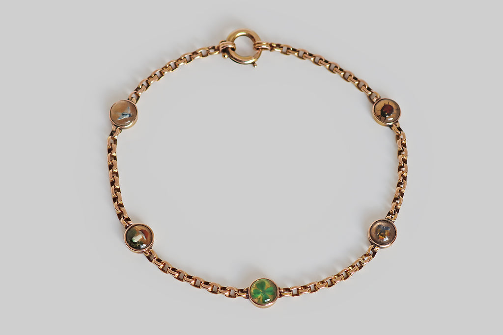 Poor Mouchette | Curated Antique Jewelry, Vintage Jewelry & Engagement Rings | Portland, Oregon | A rare and wonderful Victorian-era, cable-link bracelet, modeled in 14k rose gold, between whose stretches of faceted links miniature, reverse-painted crystals are stationed. These five, hand-painted Essex crystals are seriously dainty, and their highly-detailed, figural subjects are astonishing! Each hand-carved, hand-painted crystal is bezel set and features a lucky charm
