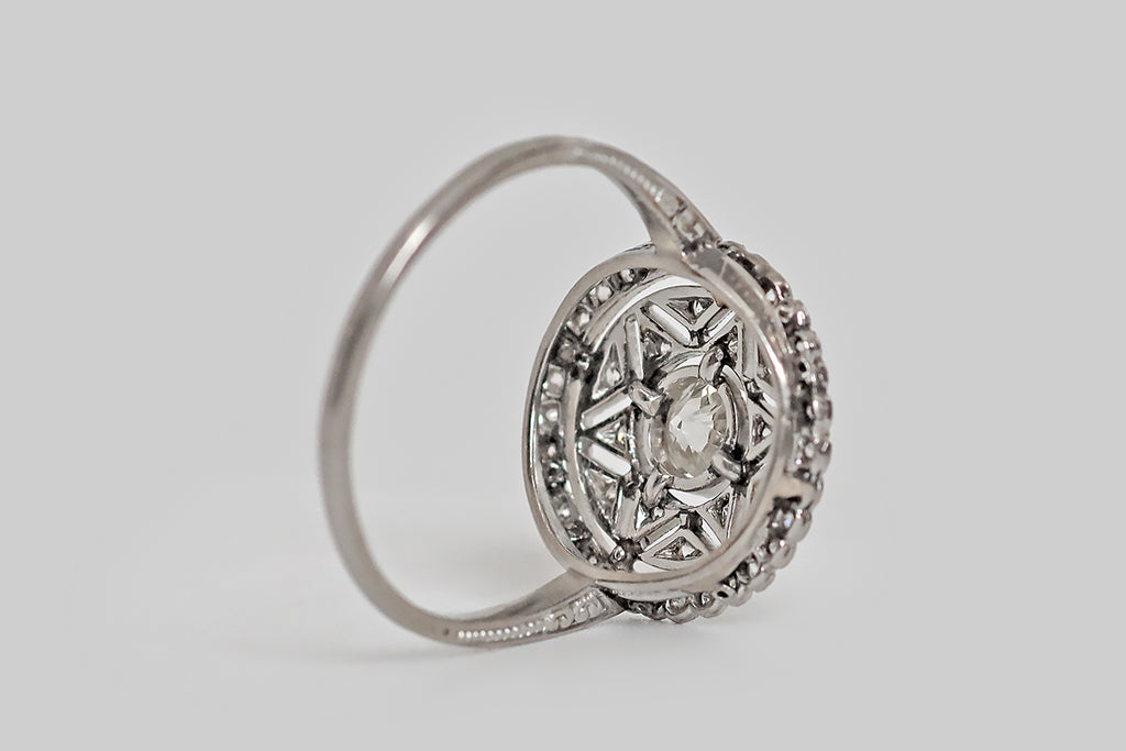 Antique Jewelry Portland, Vintage Jewelry Portland , Antique Engagement Rings | Poor Mouchette | An early 20th century engagement ring, modeled in platinum, whose central gem is a lively, .40 carat old mine cut diamond. This vibrant, white, hand-cut diamond floats in a round, milgrained bezel at the center of the ring’s six-pointed star motif. This star shape is created by a series of diamond-set, pennant-shaped seats that surround the larger, central diamond.