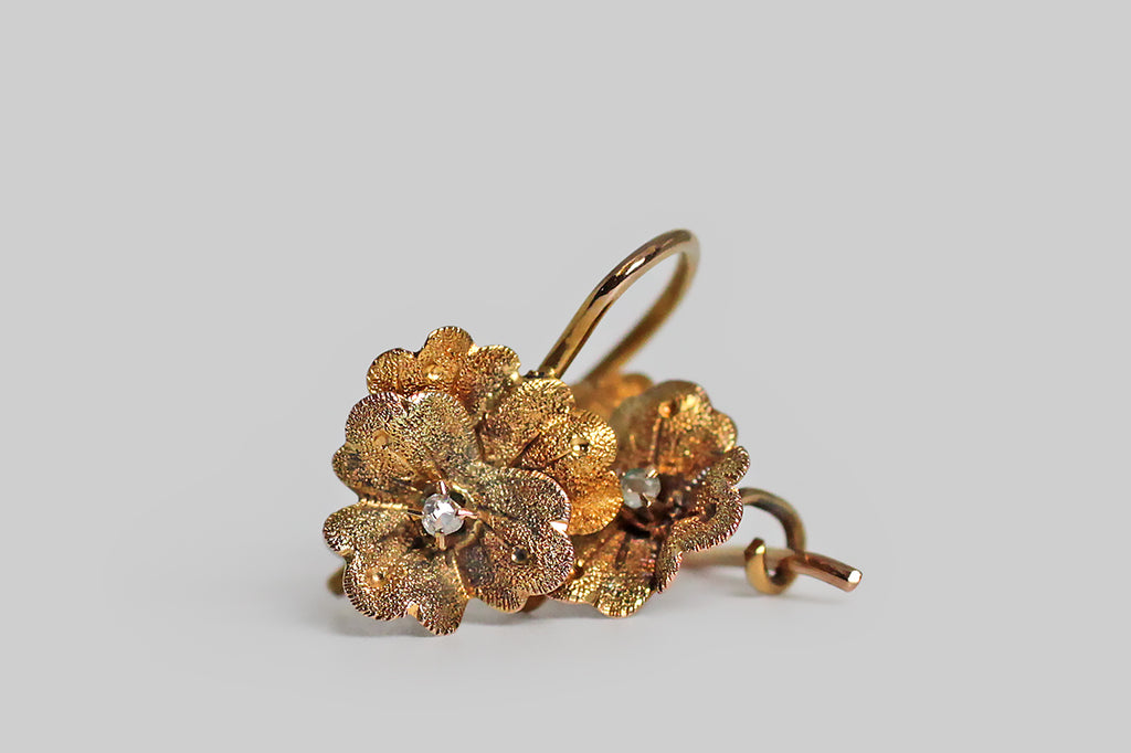 Poor Mouchette | Curated Antique Jewelry, Vintage Jewelry & Engagement Rings | Portland, Oregon | A darling pair of Victorian-era dormeuse (sleeper) earrings, modeled as miniature pansies, in 14k yellow gold. These little flowers are quite realistic, with lobed petals that bend softly, both inward and outward. The all-over, finely-stippled texture, applied to our flowers' petals, adds sparkling visual interest, while creating depth and subtle variation in color. 