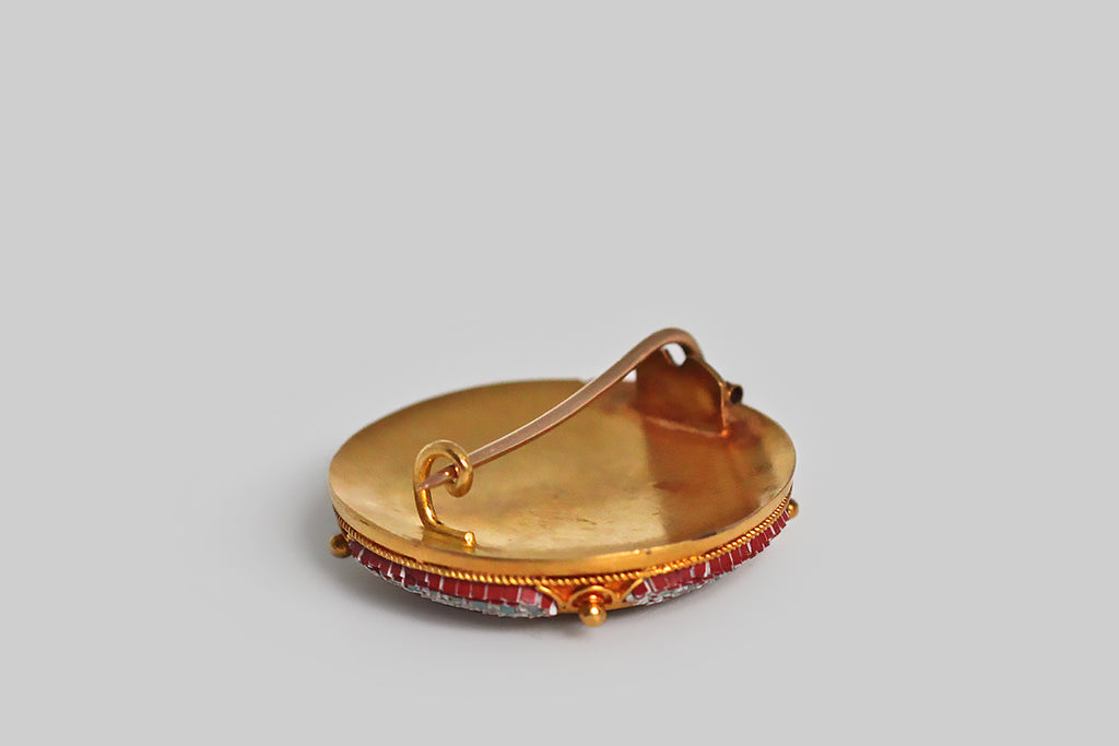 Poor Mouchette | Curated Antique Jewelry, Vintage Jewelry & Engagement Rings | Portland, Oregon | A Victorian-era micro mosaic brooch, modeled in 18k yellow gold, whose subject is Saint Peter’s Basilica, recreated here in the tiniest, most precise tesserae. This miraculous little Roman scene is held in an elegant Etruscan revival mount (closed-back), which also houses starry, curved tesserae panels that border the Vatican scene. This was made by the famous micro mosaic artist Cesare Roccheggiani