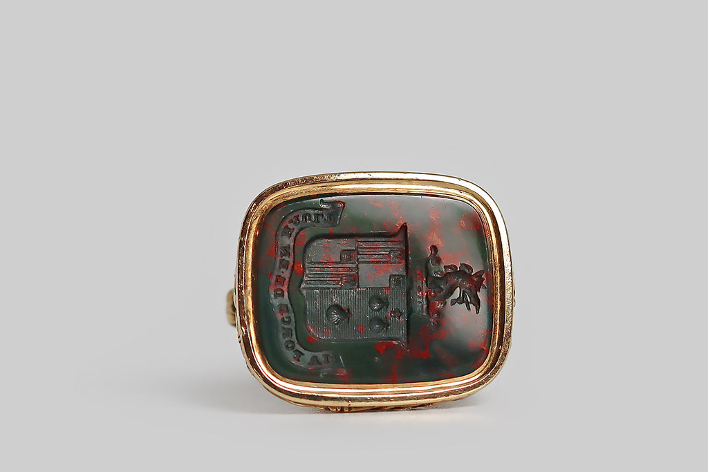 Poor Mouchette | Curated Antique Jewelry, Vintage Jewelry & Engagement Rings | Portland, Oregon | A wonderful, large fob (late-Georgian/early-Victorian fob), modeled in 14k yellow gold and set with a rectangular, intaglio-carved, bloodstone gem. This finely-carved wax seal features a coat of arms, atop which sits a coronet-collared dragon. This coat of arms is "impaled" to indicate a marriage— on the sinister side, we have a series of three seashells and a small star