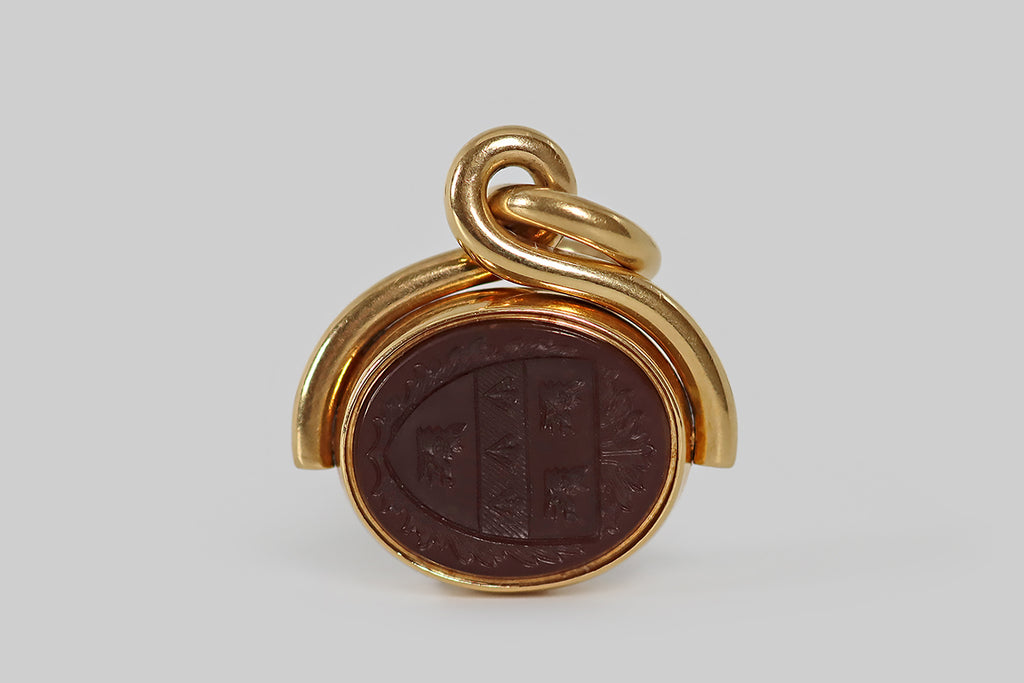 Antique Jewelry Portland, Vintage Jewelry Portland , Antique Engagement Rings | Poor Mouchette | A wonderful Victorian-era swiveling fob, modeled in 18k yellow gold and set with a pair of intaglio carved seals, one carnelian and the other bloodstone. The carnelian seal is a rich wine color— it depicts the Hutchison family coat of arms (Clan Donald) which is intricately carved with three boar's heads and three arrow heads.