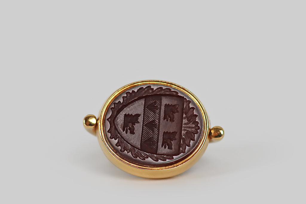 Antique Jewelry Portland, Vintage Jewelry Portland , Antique Engagement Rings | Poor Mouchette | A wonderful Victorian-era swiveling fob, modeled in 18k yellow gold and set with a pair of intaglio carved seals, one carnelian and the other bloodstone. The carnelian seal is a rich wine color— it depicts the Hutchison family coat of arms (Clan Donald) which is intricately carved with three boar's heads and three arrow heads.