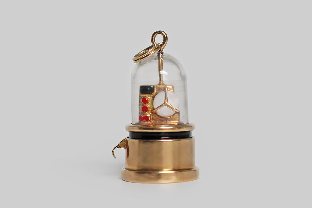Poor Mouchette | Curated Antique Jewelry, Vintage Jewelry & Engagement Rings | Portland, Oregon | A rare mid twentieth century charm, modeled in 14k yellow gold, after the Edison ticker tape machine. This sweet, miniature stock ticker is decorated with enamel (in red, white and black), and enclosed inside a clear, bell-shaped cloche. Ticker tape machines were the earliest dedicated financial communications system— they transmitted stock price information 