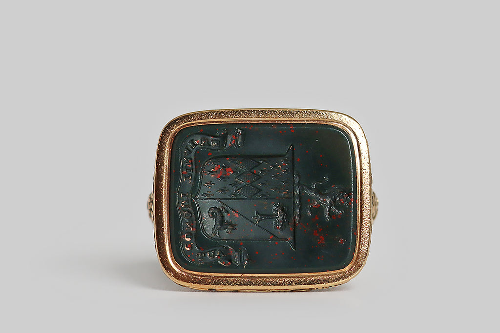 Poor Mouchette | Curated Antique Jewelry, Vintage Jewelry & Engagement Rings | Portland, Oregon | A striking, extra-large, Georgian era fob, modeled in 14k yellow gold and set with a rectangular, intaglio-carved, bloodstone gem. This finely-carved wax seal features a coat of arms, atop which stands a rampant lion. This coat of arms is "impaled" to indicate a marriage. The sinister field is divided, diagonally, "party per bend—" the charge depicted in the top half of this field is an eradicated tree