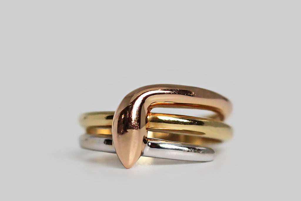 A vintage snake ring, with a serene, minimalist presence, modeled in three colors of 18k gold. This sweet, dignified serpent wraps the finger three times, and each of its three colors (rose, yellow, and white) are especially vibrant. Snakes have long been regarded as guardians, so this ring makes a lovely statement as a protective amulet. It is also flattering in wear and very comfortable, making it an ideal alternative wedding band. 