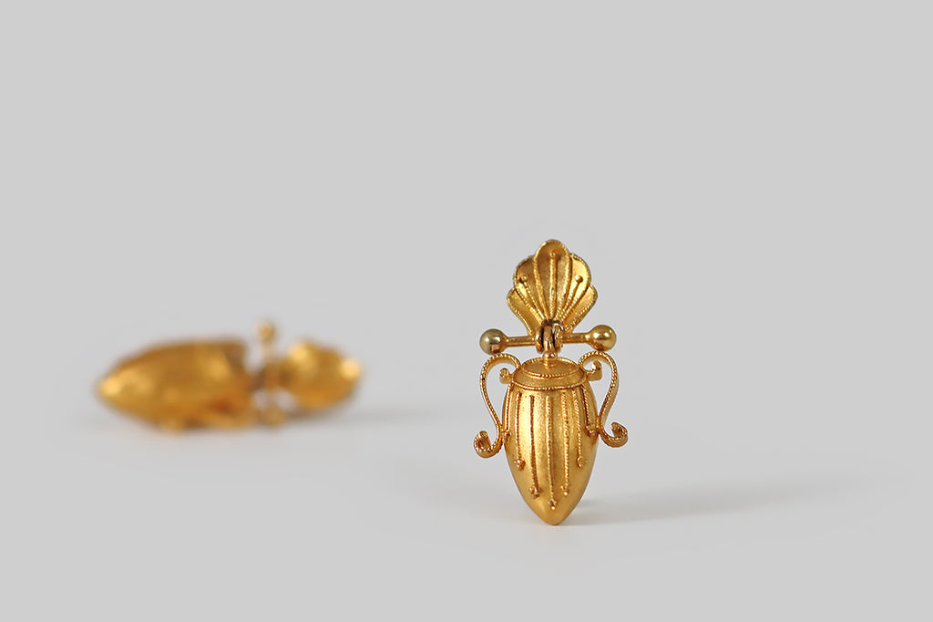Antique Jewelry Portland, Vintage Jewelry Portland , Antique Engagement Rings | Poor Mouchette | A pair of antique, Victorian-era earrings, made in the Etruscan style, and modeled in 14k yellow gold. These elegant earrings were designed with shell-form tops, below which hang drops made to resemble Greek amphorae. A barbell joins these two elements, allowing the amphorae to swing, gently, with movement. The earwires are locking kidney wires, and they are hinged at the top.