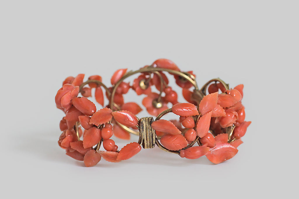 Poor Mouchette | Curated Antique Jewelry, Vintage Jewelry & Engagement Rings | Portland, Oregon | A romantic, Victorian era, hinged cuff bracelet, modeled in 14k yellow gold, that takes the form of a briary, trellised arrangment of roses. The bracelet's plump roses, rosebuds, and serrate leaves are each masterfully hand-carved from natural, salmon-colored coral. They are individually mounted atop a substantial, wirework frame