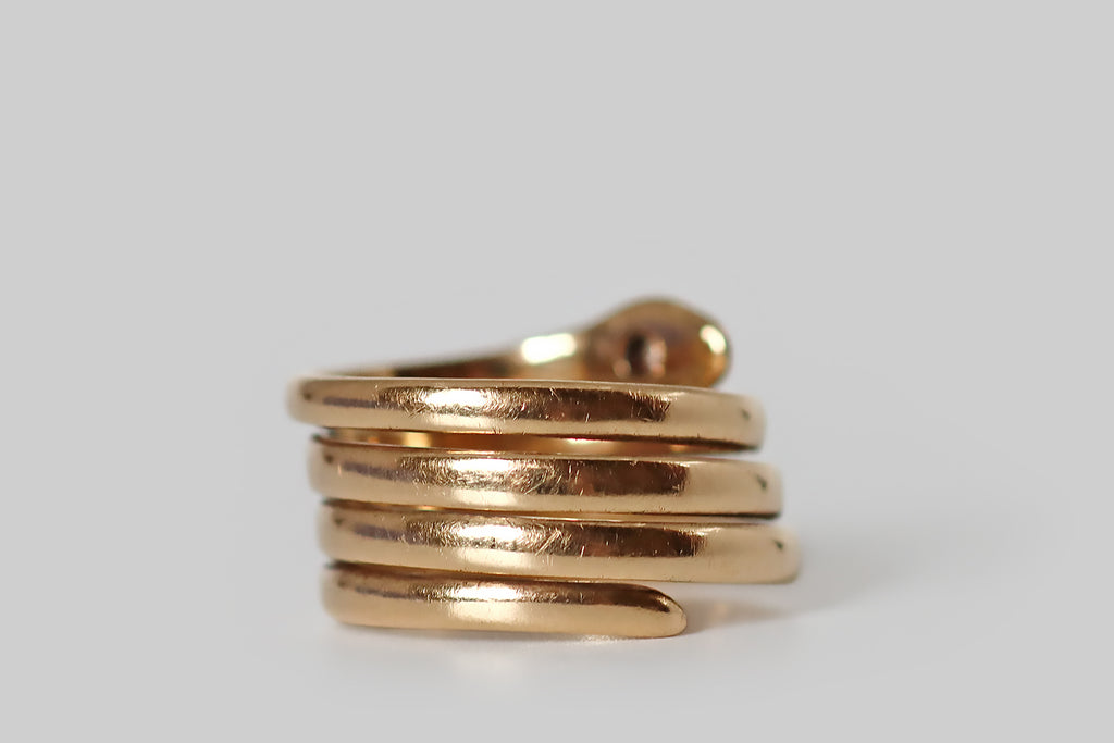 Antique Jewelry Portland, Vintage Jewelry Portland , Antique Engagement Rings | Poor Mouchette | An extra-charming Victorian era snake ring, made from one continuous, coiling, 14k gold band, which wraps the wearer’s finger four times. This rosy yellow-gold snake has sweet, subtle face details— he rests his diamond-set head atop his coiled body, and he has a little, trailing, whip-like tail.