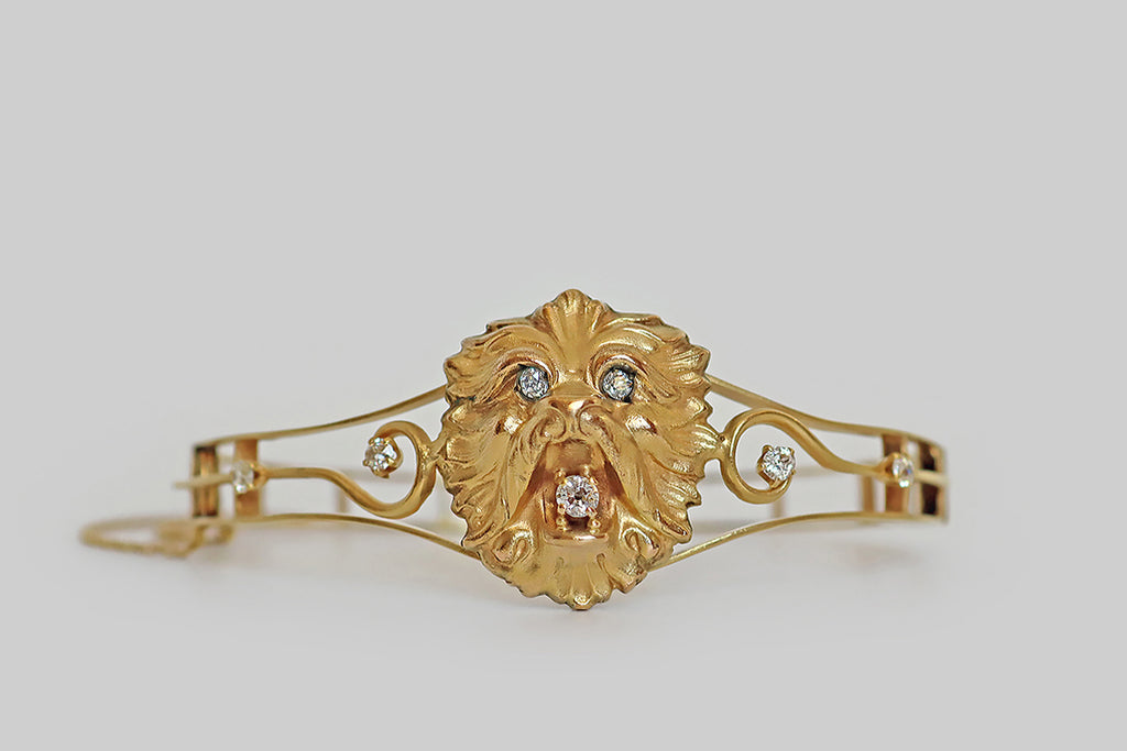 Poor Mouchette | Curated Antique Jewelry, Vintage Jewelry & Engagement Rings | Portland, Oregon | An exceptional Art Nouveau era bangle bracelet, modeled in bloomed 14k gold, whose primary element is a beautifully sculpted (Shih Tzu) dog mask, made in the manner of the popular lion masks of the era. Our brave little canine holds a sparkling, white, old mine cut diamond in his mouth, and his shining eyes are also set with old mine cut diamonds.