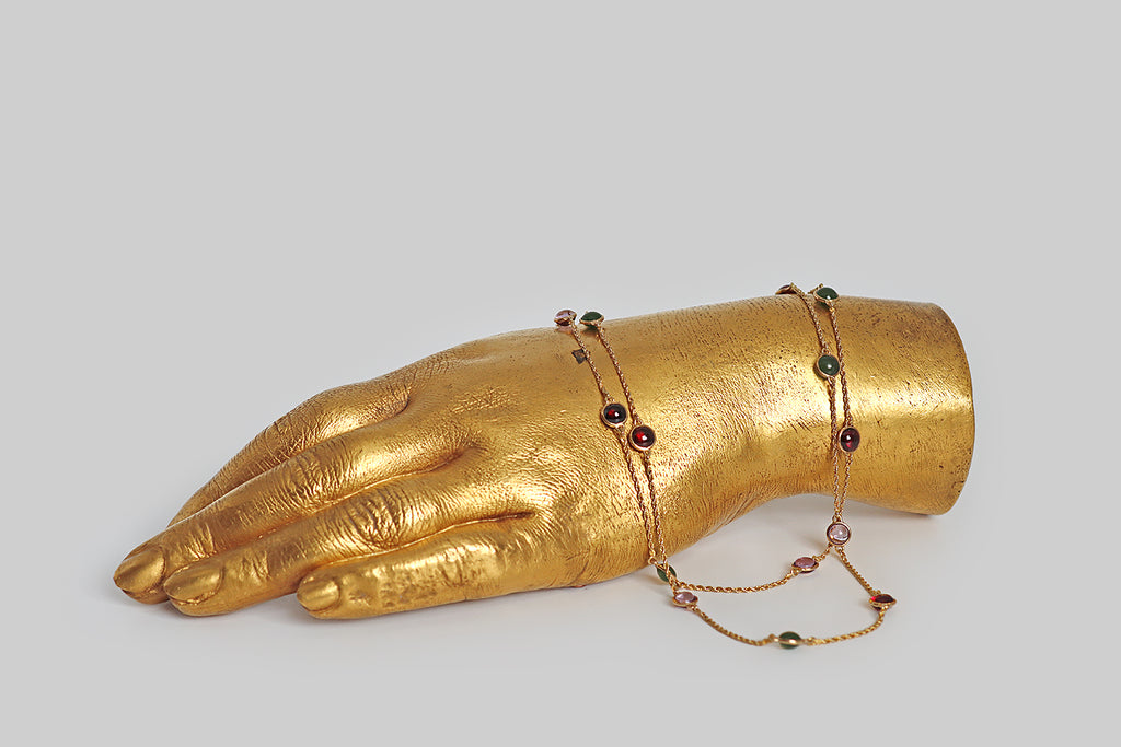 Poor Mouchette | Curated Antique Jewelry, Vintage Jewelry & Engagement Rings | Portland, Oregon | A striking, Victorian era, long guard station chain, modeled in 14k yellow gold, whose lengths of slender, twisted rope are punctuated with bezel-set, gemstone spacers. These amethyst, garnet, and nephrite jade cabochons are domed on both sides— they are mounted in slim, “floating” bezels, so they are never upside down. This antique chain is fitted with a 14k gold dog clip