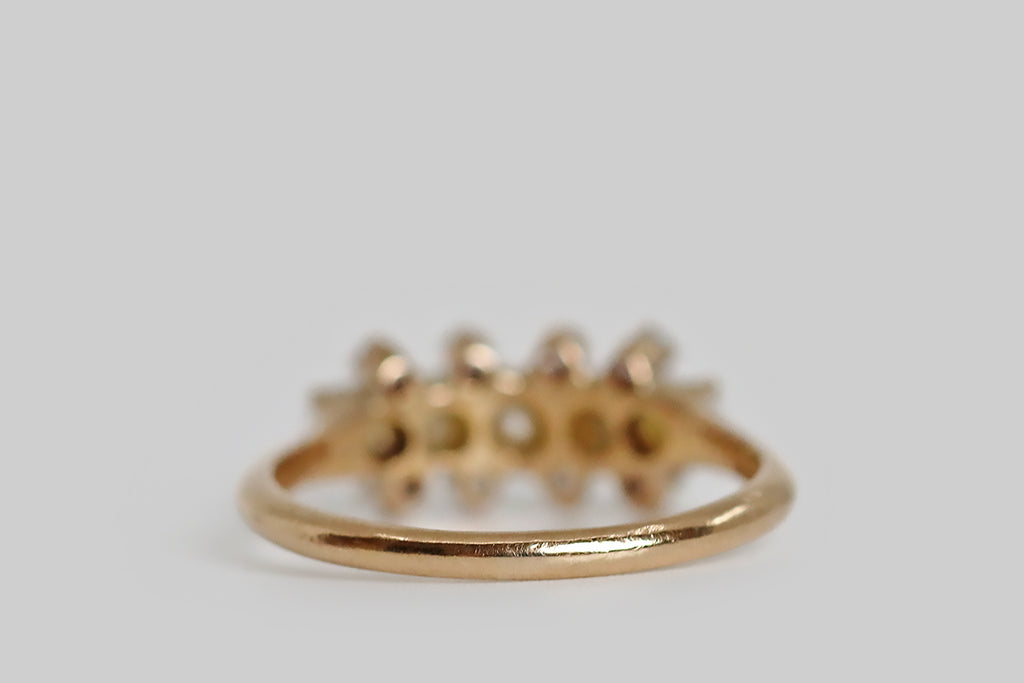 Poor Mouchette | Curated Antique Jewelry, Vintage Jewelry & Engagement Rings | Portland, Oregon | A delicate, Victorian-era cluster ring, modeled in 14k rosy-yellow gold, whose five primary gems are a series of luminous, white half-pearls. These pearls are set horizontally, across the curved ring face, in shared claw-like prongs. They are subtly graduated, with the largest pearl resting at center. Eight, small, old mine cut diamonds further decorate the ring face
