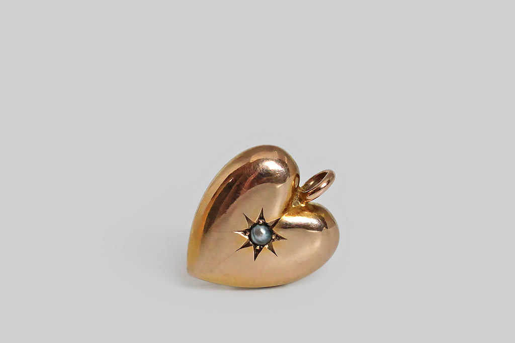 Poor Mouchette | Curated Antique Jewelry, Vintage Jewelry & Engagement Rings | Portland, Oregon | A charming, Victorian era heart pendant, modeled in 9k rosy yellow gold. This classic puffed heart is beautifully and substantially made— it has a lovely form, with smooth edges, and thick-walled construction. An expressively-carved, eight-pointed star rests at the center of this heart, where it holds a silvery, semi-baroque seed pearl. This is a wonderful, easy-to-wear, everyday pendant