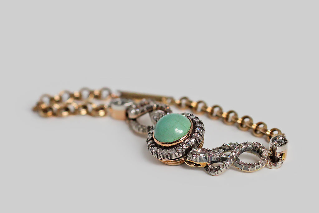Poor Mouchette | Curated Antique Jewelry, Vintage Jewelry & Engagement Rings | Portland, Oregon | A very special Victorian-era bracelet, modeled in 14k gold with a silver top, featuring a pair of snakes (each coiled into an infinity shape) that guard a central, round, turquoise cabochon. This blue-green gem is mounted in a gold bezel, where it is haloed by a bevy of glinting rose cut diamonds— the diamonds are held in silver, cut-down collet settings.