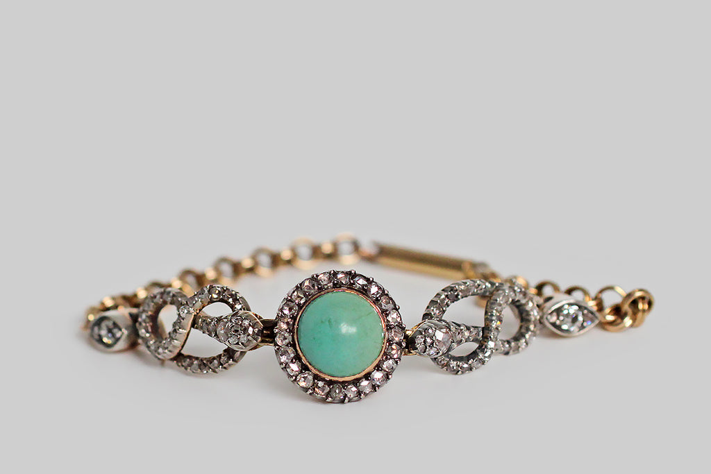 Poor Mouchette | Curated Antique Jewelry, Vintage Jewelry & Engagement Rings | Portland, Oregon | A very special Victorian-era bracelet, modeled in 14k gold with a silver top, featuring a pair of snakes (each coiled into an infinity shape) that guard a central, round, turquoise cabochon. This blue-green gem is mounted in a gold bezel, where it is haloed by a bevy of glinting rose cut diamonds— the diamonds are held in silver, cut-down collet settings.