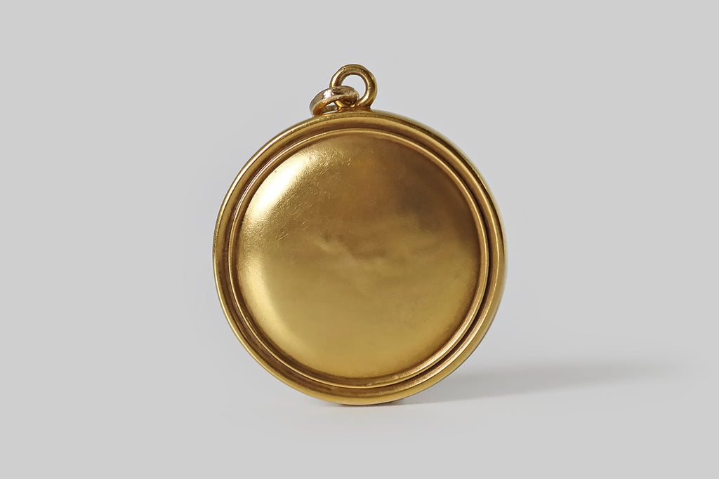 Poor Mouchette | Curated Antique Jewelry, Vintage Jewelry & Engagement Rings | Portland, Oregon | A wonderful Art Nouveau era, repoussé locket, modeled in 14k yellow gold, whose fierce subject is a lion sitting in profile amid a clutch of tall grasses. Our lion is realistically rendered, with a snarling, focused expression; his long, wavy mane mingles with the graceful blades of grass that surround him. He holds a sparkling, prong-set, old mine cut diamond in his mouth.