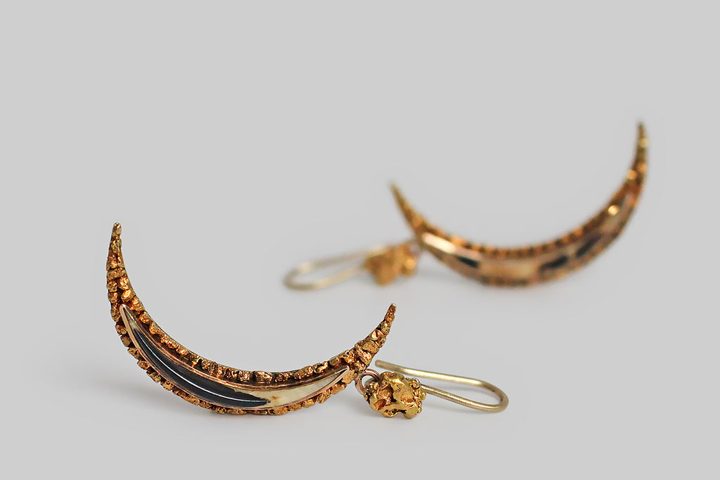 A soulful pair of dangling earrings, fashioned from Victorian-era components. These earrings feature two, slender, crescent moons, each set with a fine, beautifully-figured, horn cabochon. The cabochons are set in smooth bezels, where they are surrounded by a carefully-constructed border of high-karat-gold, natural, placer nuggets. These gold-rush-era nugget moons hang
