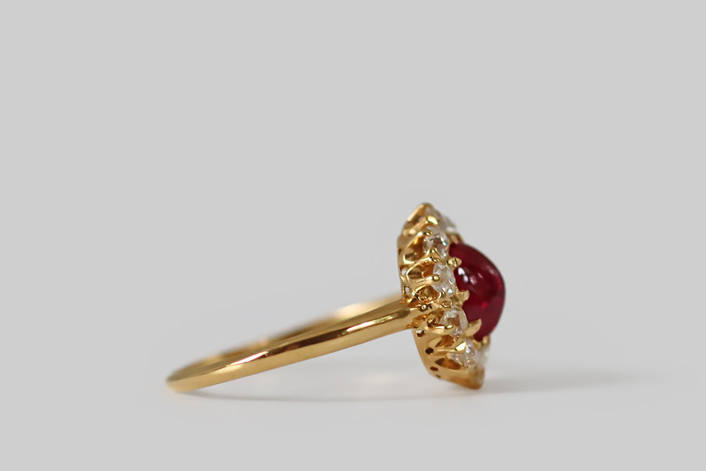 Antique Jewelry Portland, Vintage Jewelry Portland , Antique Engagement Rings | Poor Mouchette | A beautiful, antique, Tiffany & Co. ring, modeled in 18k yellow gold, whose primary gem is a natural, untreated, .93 carat sugarloaf ruby cabochon (AGL certified) encircled by a halo of ten chunky, old European cut diamonds. This oval, 'pigeon's blood' ruby cabochon is transparent and deeply-saturated