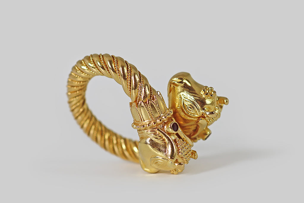 Poor Mouchette | Curated Antique Jewelry, Vintage Jewelry & Engagement Rings | Portland, Oregon | A poetic, vintage bypass ring, modeled in 22k yellow gold by the beloved Greek designer Ilias Lalaounis. This ring is bold and glamorous, featuring a pair of stylized bull’s head finials, that lean sweetly together where its bypass overlaps. The ring's shank is fully round and weighty, with a twisted wire decor that tightens at the base. Minotaur