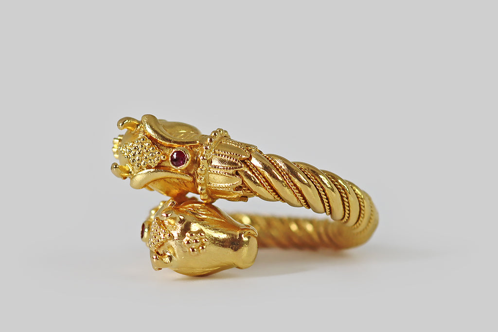 Poor Mouchette | Curated Antique Jewelry, Vintage Jewelry & Engagement Rings | Portland, Oregon | A poetic, vintage bypass ring, modeled in 22k yellow gold by the beloved Greek designer Ilias Lalaounis. This ring is bold and glamorous, featuring a pair of stylized bull’s head finials, that lean sweetly together where its bypass overlaps. The ring's shank is fully round and weighty, with a twisted wire decor that tightens at the base. Minotaur